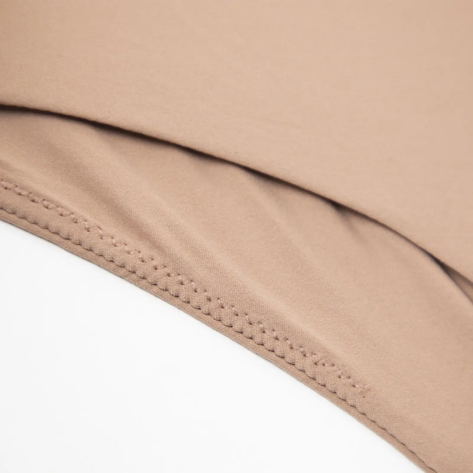 Close-up of the thong bottom of a beige bodysuit.