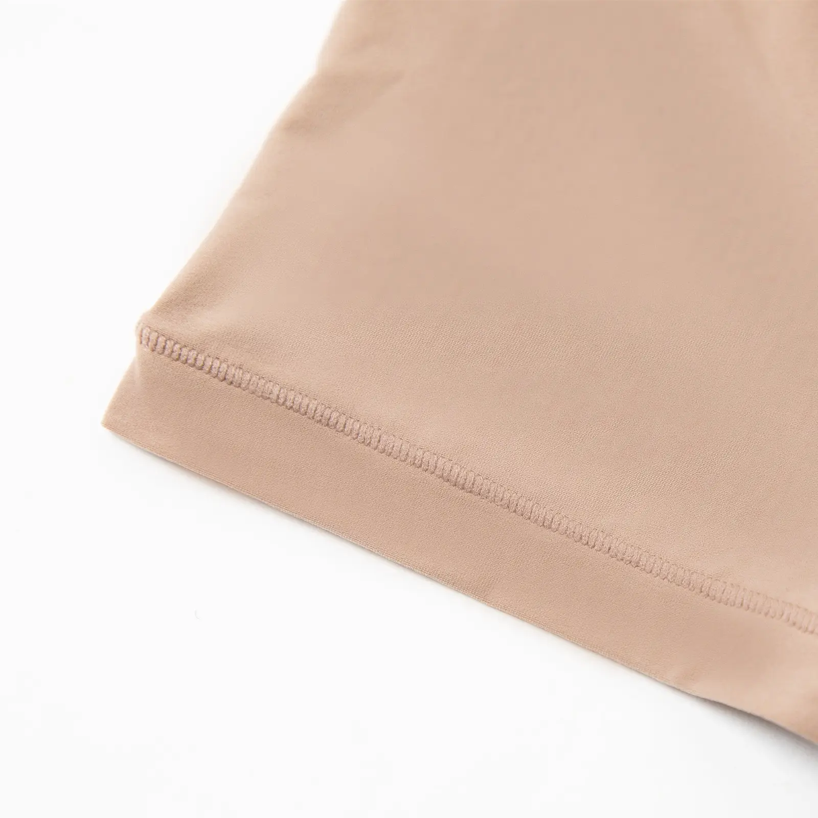 Close-up of the sleeve of a beige t-shirt bodysuit.