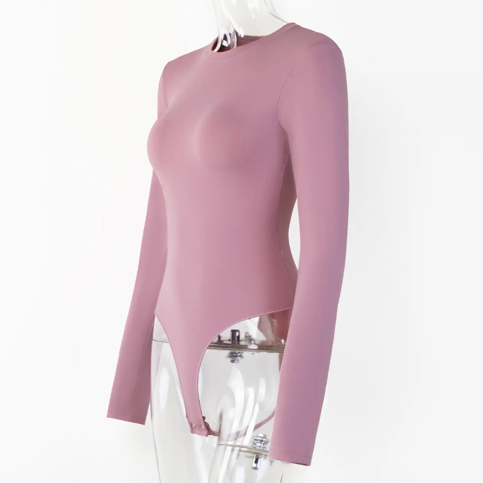 Transparent torso acrylic mannequin wearing a long sleeve crew cut bodysuit over a white background