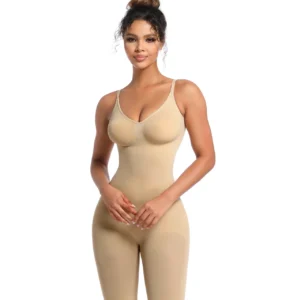 Mixed-race woman with her hair up, poses wearing a beige high-compression mid-thig bodysuit with a white background.