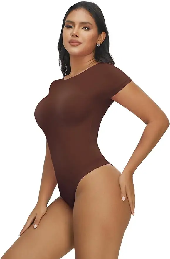 Hispanic woman posing with hand on hip wearing a brown t-shirt bodysuit over a white background